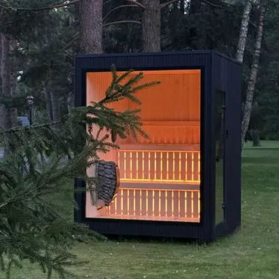 Jonas Classic Outdoor Sauna in Ebony mit Glasfront und warm beleuchtetem Innenraum im Garten.