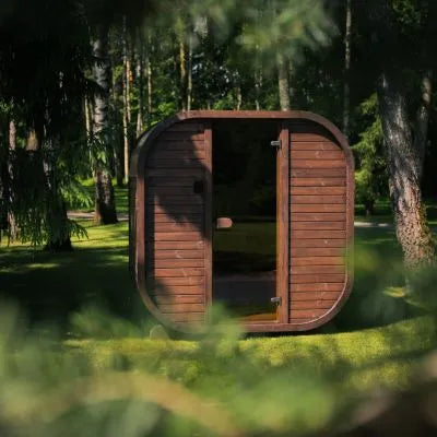 Ula Mini Sauna in Teak mit Glastür in einem grünen Garten